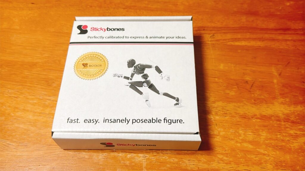 Stickybonesのパッケージ箱。走るポーズのフィギュアが印刷されており、木のテーブルの上に置かれている。